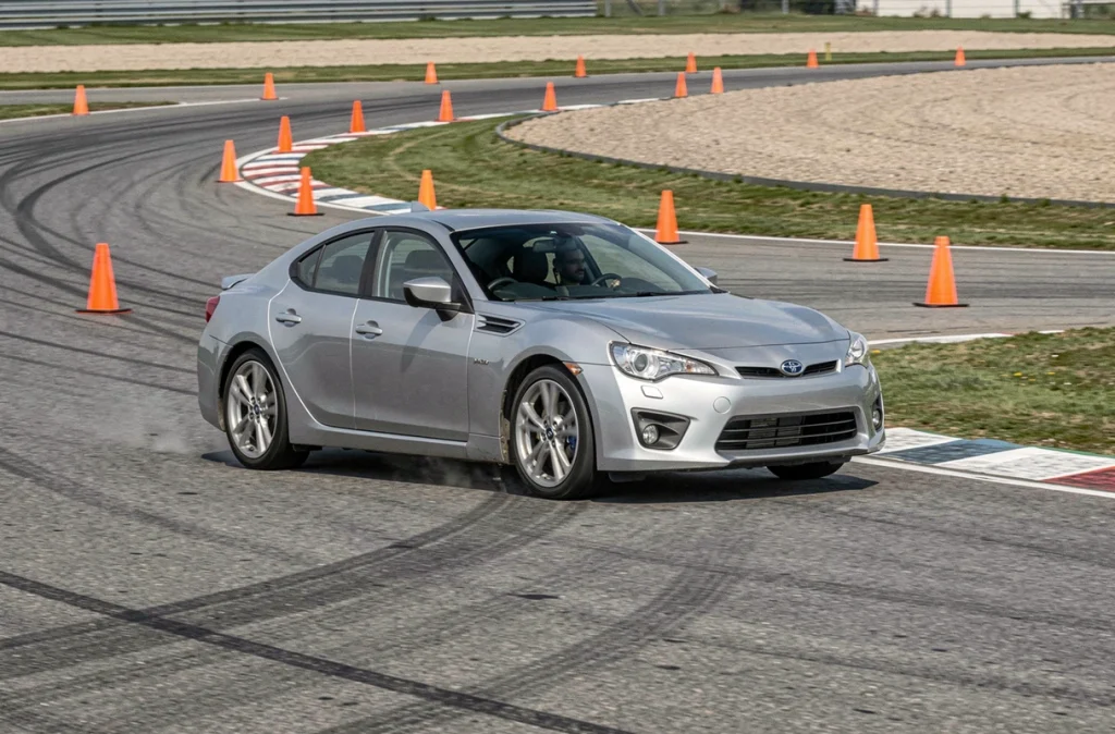 Voiture de sport en train de négocier une chicane sur circuit lors d'un stage de pilotage