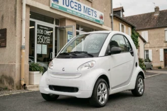 Voiture sans permis blanche devant un concessionnaire d'occasion en Auvergne avec étiquette de prix sur le pare-brise